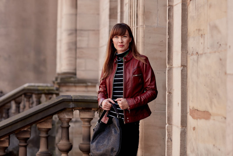 Woman outside building in a red leather jacket